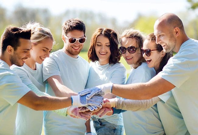 A group of people holding hands in the middle of a circle.