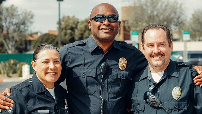 A police officer and two other people standing next to each other.